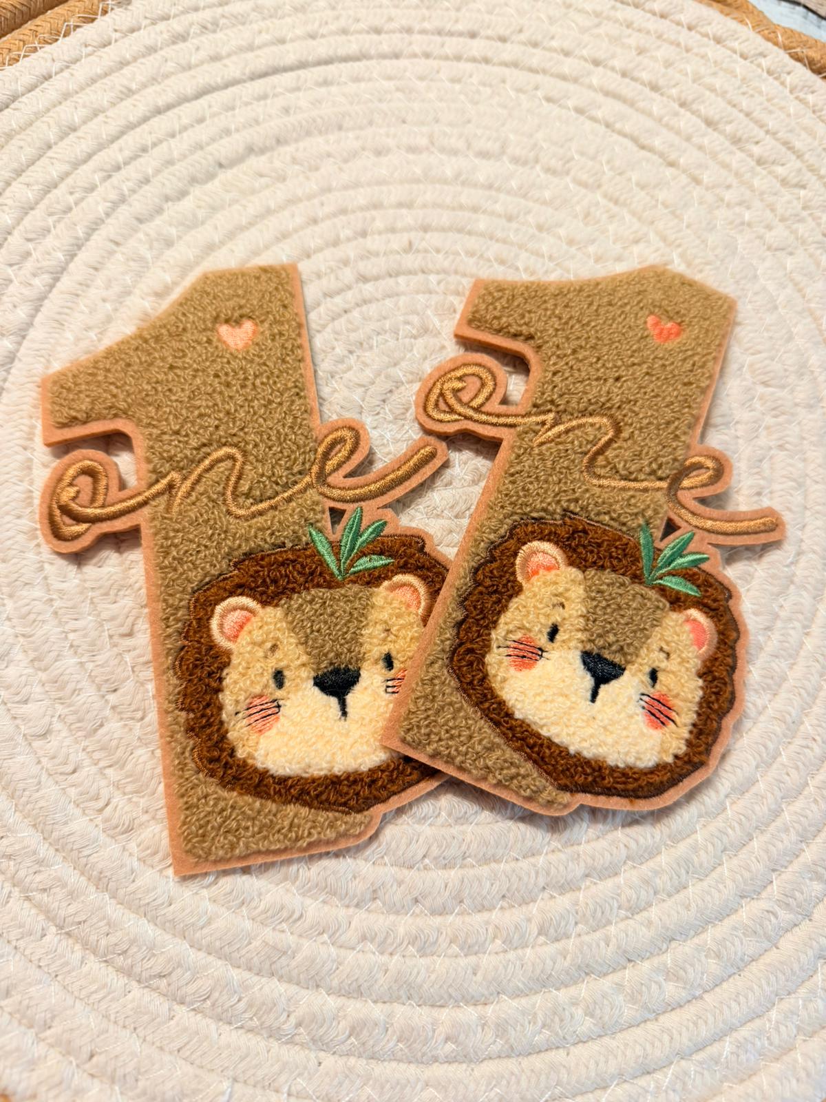 wunderschönes braunes Chenille Patch mit einem kleinen Löwengesicht der Zahl Eins und dem Schriftzug One