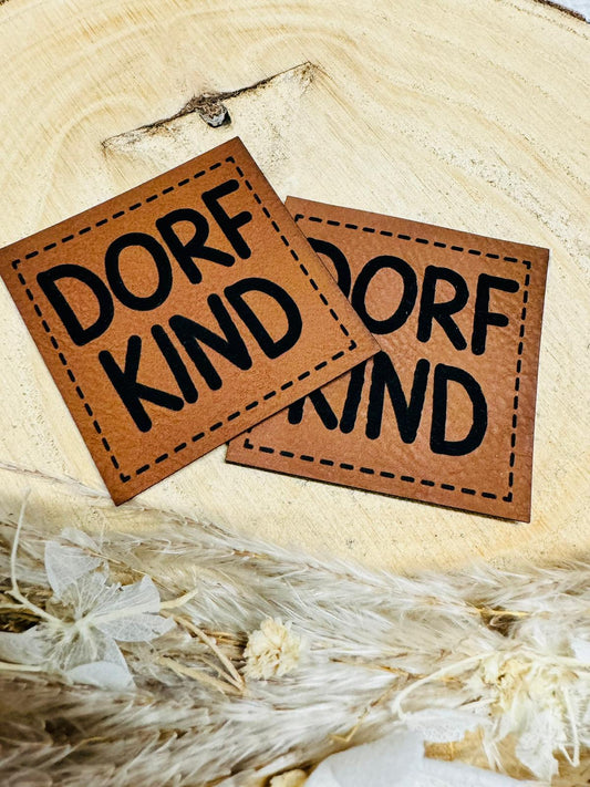 braunes  kunstlederlabel mit dem spruch dorfkind