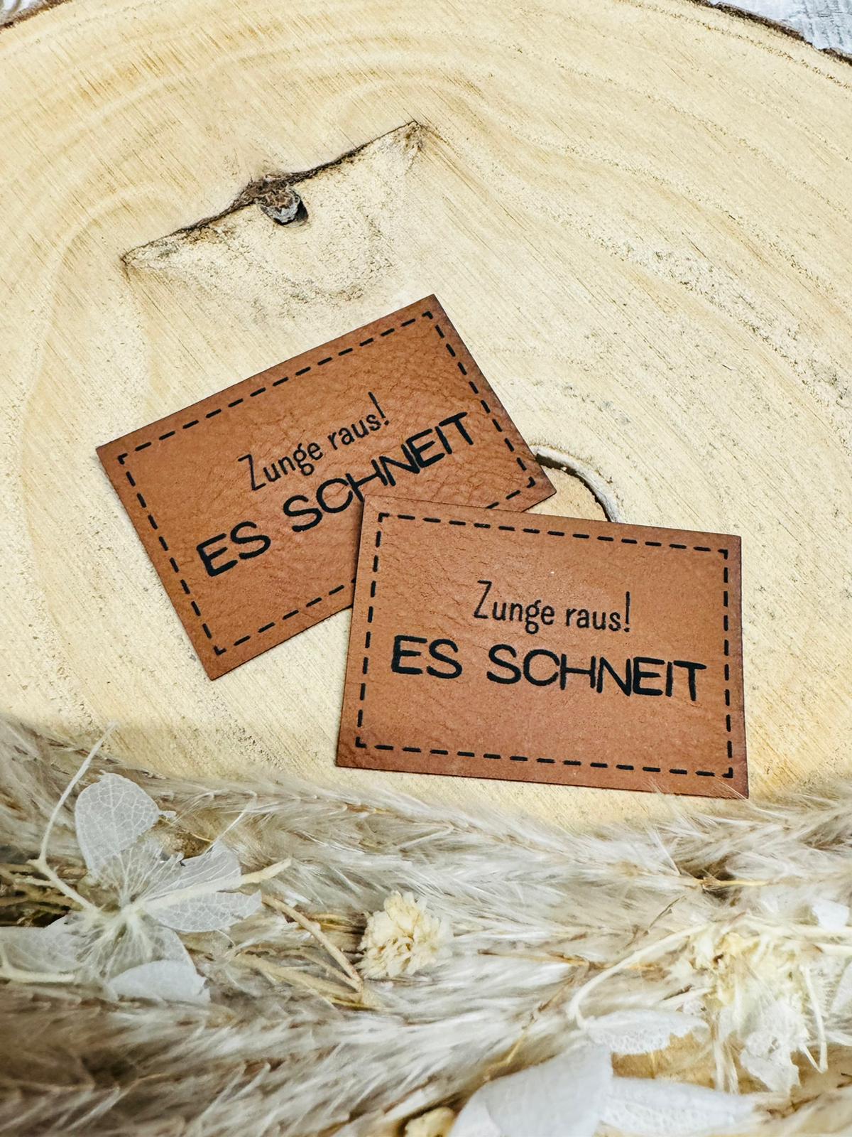 braunes  kunstlederlabel mit dem spruch zunge raus es schneit