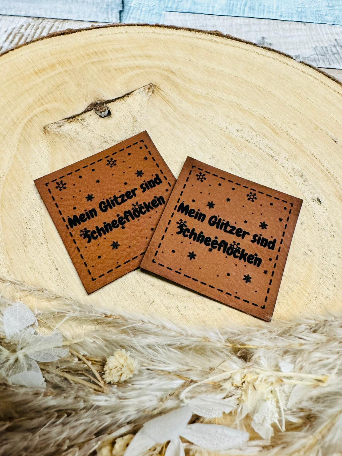 braunes  kunstlederlabel mit dem spruch mein glitzer sind schneeflocken