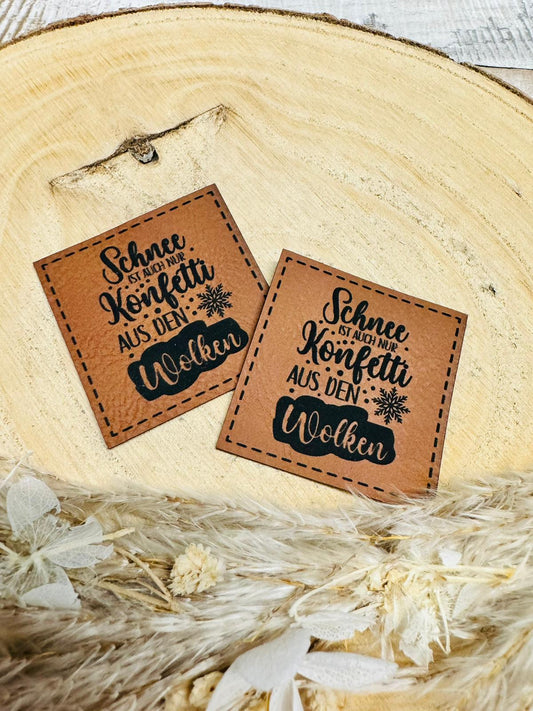 braunes christmas kunstlederlabel mit dem spruch schnee ist auch nur konfetti aus den wolken