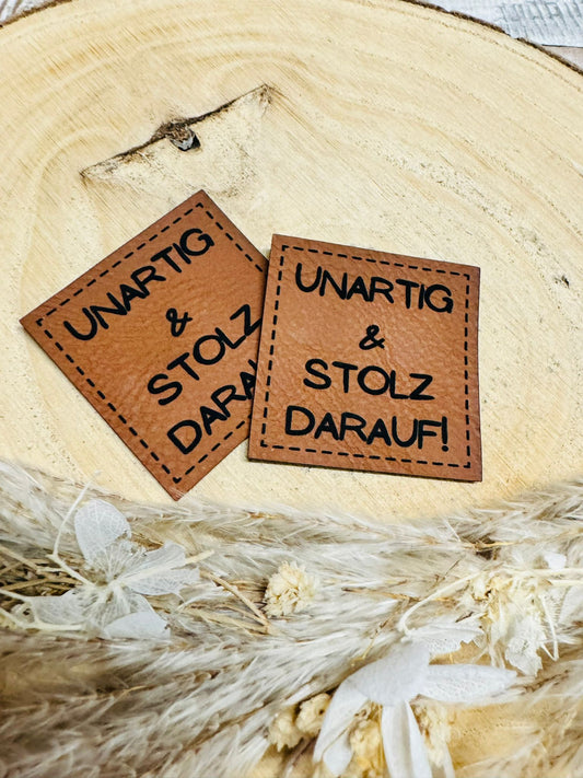braunes christmas kunstlederlabel mit dem spruch nartig und stolz darauf ausrufezeichen
