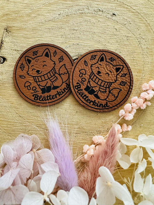 superweiches rundes braunes Kunstlederlabel mit dem Spruch Blätterkind und einem kleinen Fuchs abgebildet