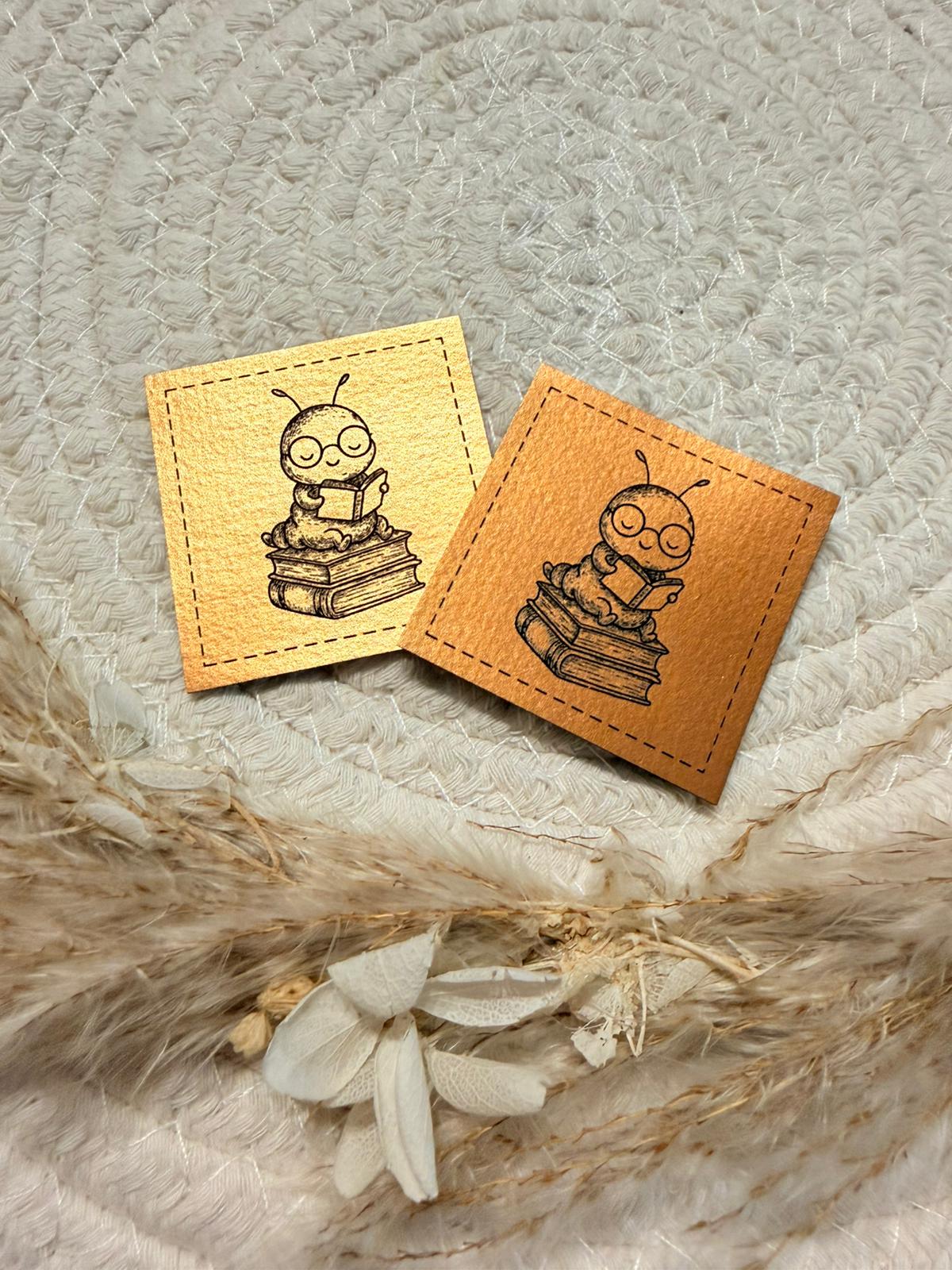 superweiches bronzenfarbenes  gebürstetes Kunstlederlabel mit einem kleinen Bücherwurm abgebildet