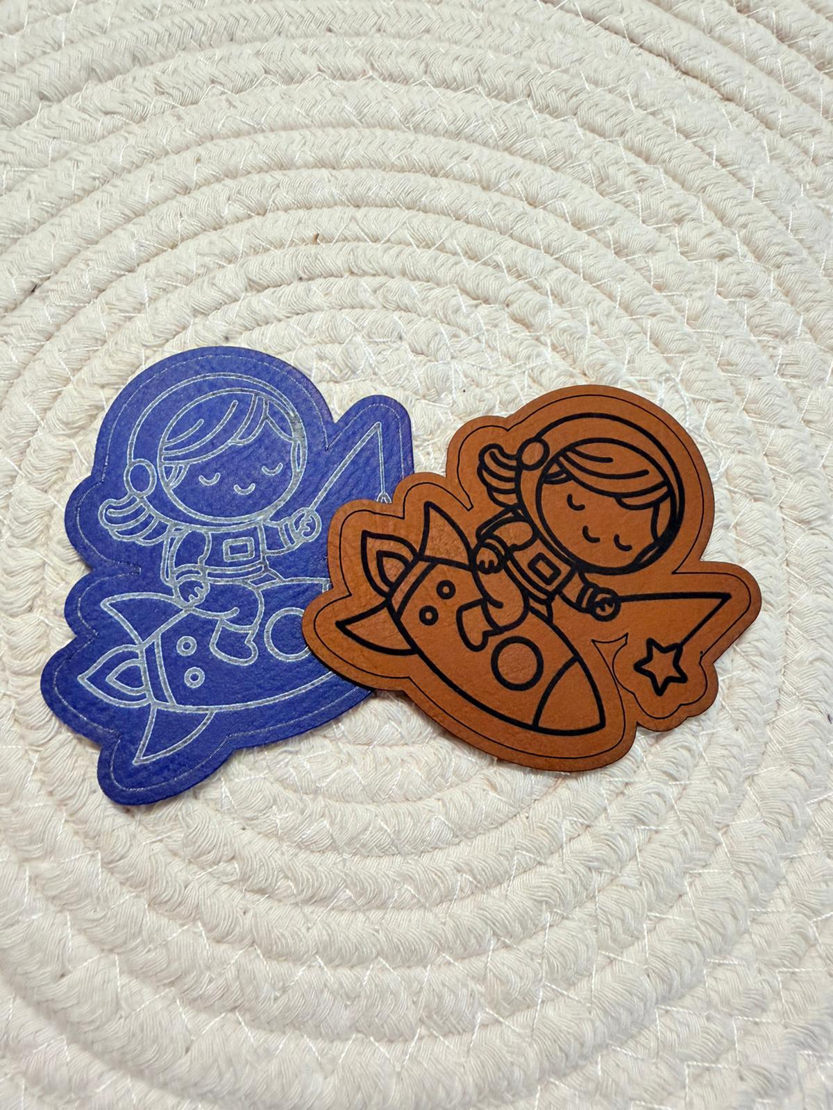 superweiches Kontur Kunstlederlabel mit einem kleinen Girl auf einer Rakete sitzend in blau und braun 