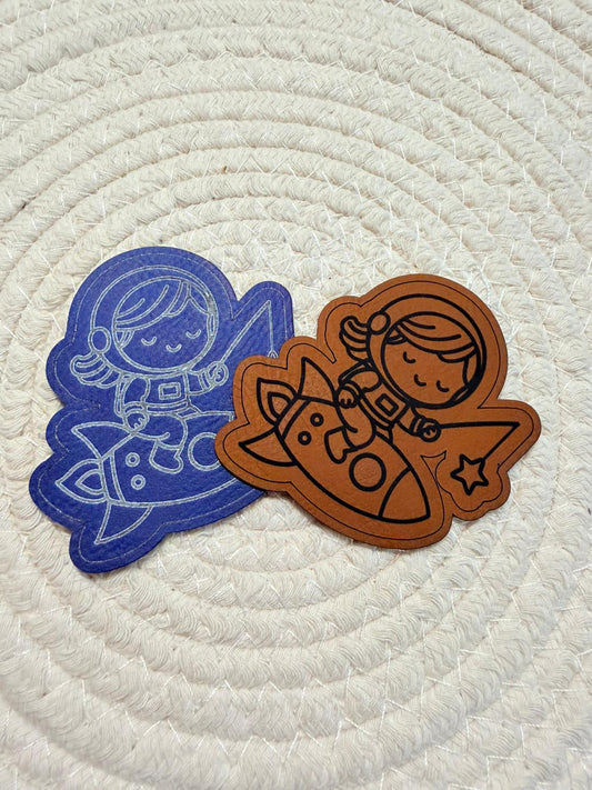 superweiches Kontur Kunstlederlabel mit einem kleinen Girl auf einer Rakete sitzend in blau und braun 