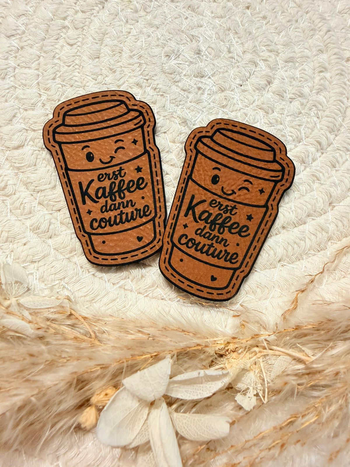 superweiches braunes Kontur Kunstlederlabel mit dem Spruch erst Kaffee dann Couture und einem augenzwinkernden Kaffe-to-go-Becher abgebildet