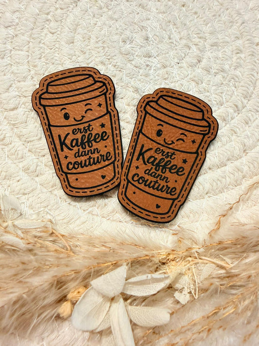 superweiches braunes Kontur Kunstlederlabel mit dem Spruch erst Kaffee dann Couture und einem augenzwinkernden Kaffe-to-go-Becher abgebildet