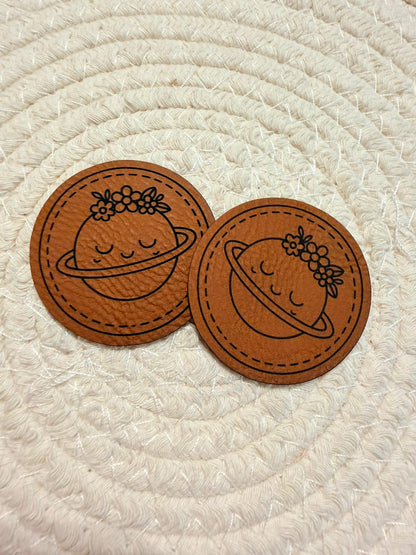 superweiches rundes braunes Kunstlederlabel mit einem blumengeschmückten Planeten
