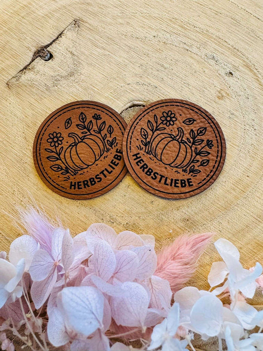 superweiches rundes braunes Kunstleder Label mit dem Spruch Herbstliebe und einem kleinen herbstlich dekorierten Kürbis abgebildet