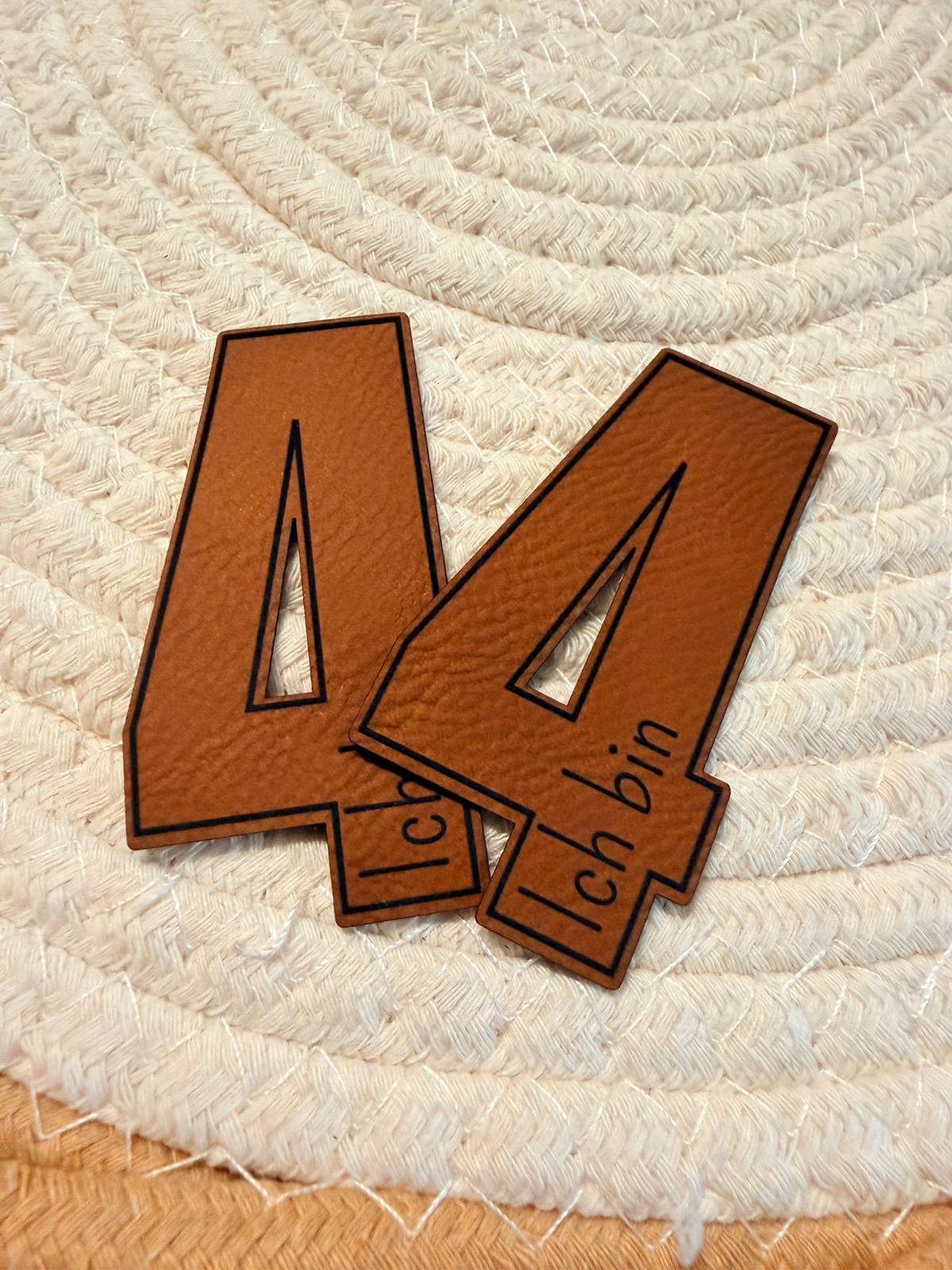 superweiches braunes Kontur Kunstlederlabel in Form einer Vier und dem Spruch Ich bin darin