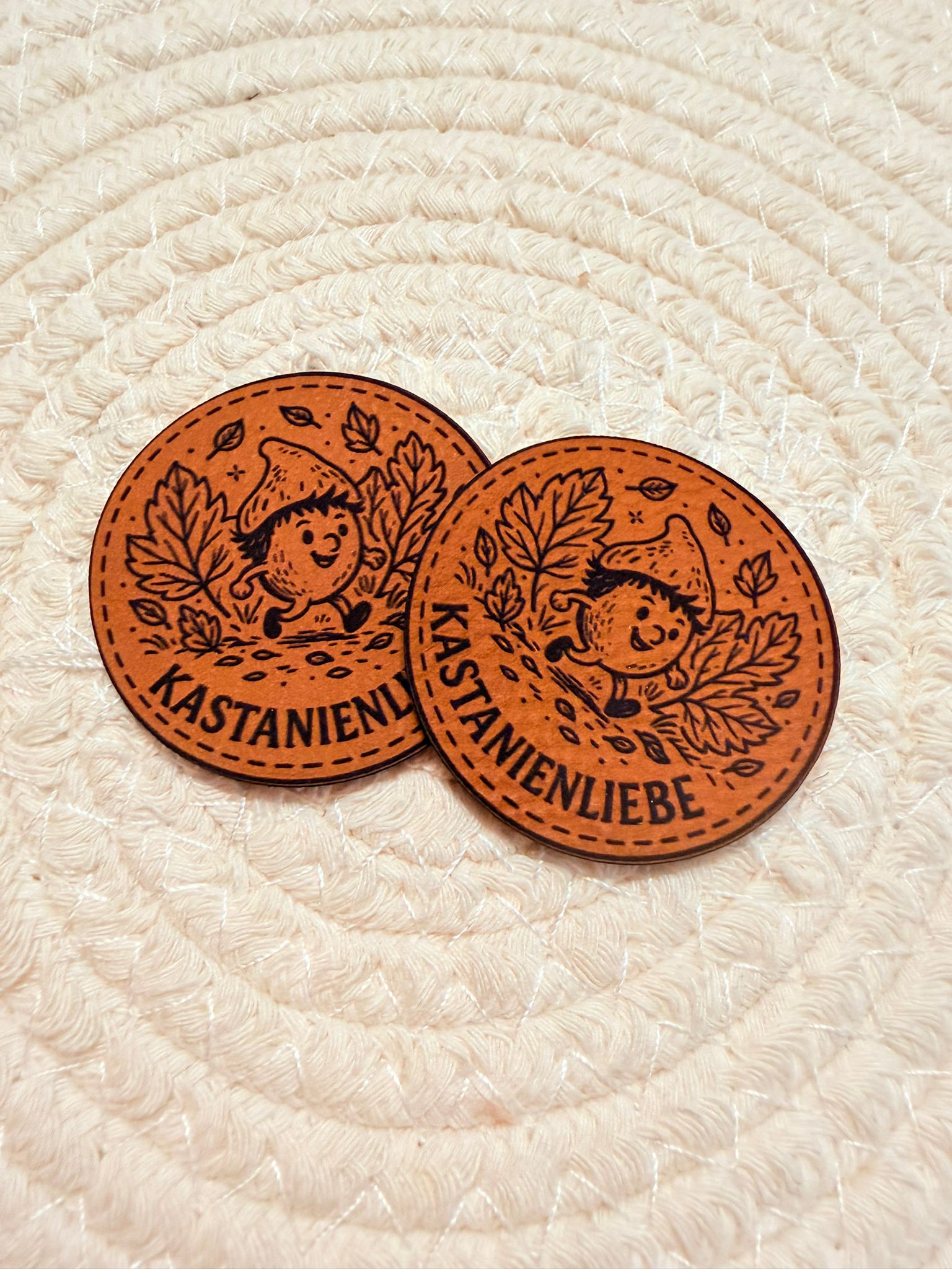 superweiches braunes rundes Kunstlederlabel mit dem Spruch Kastanienliebe und einer kleinen im Herbstwald laufenden Kastanie