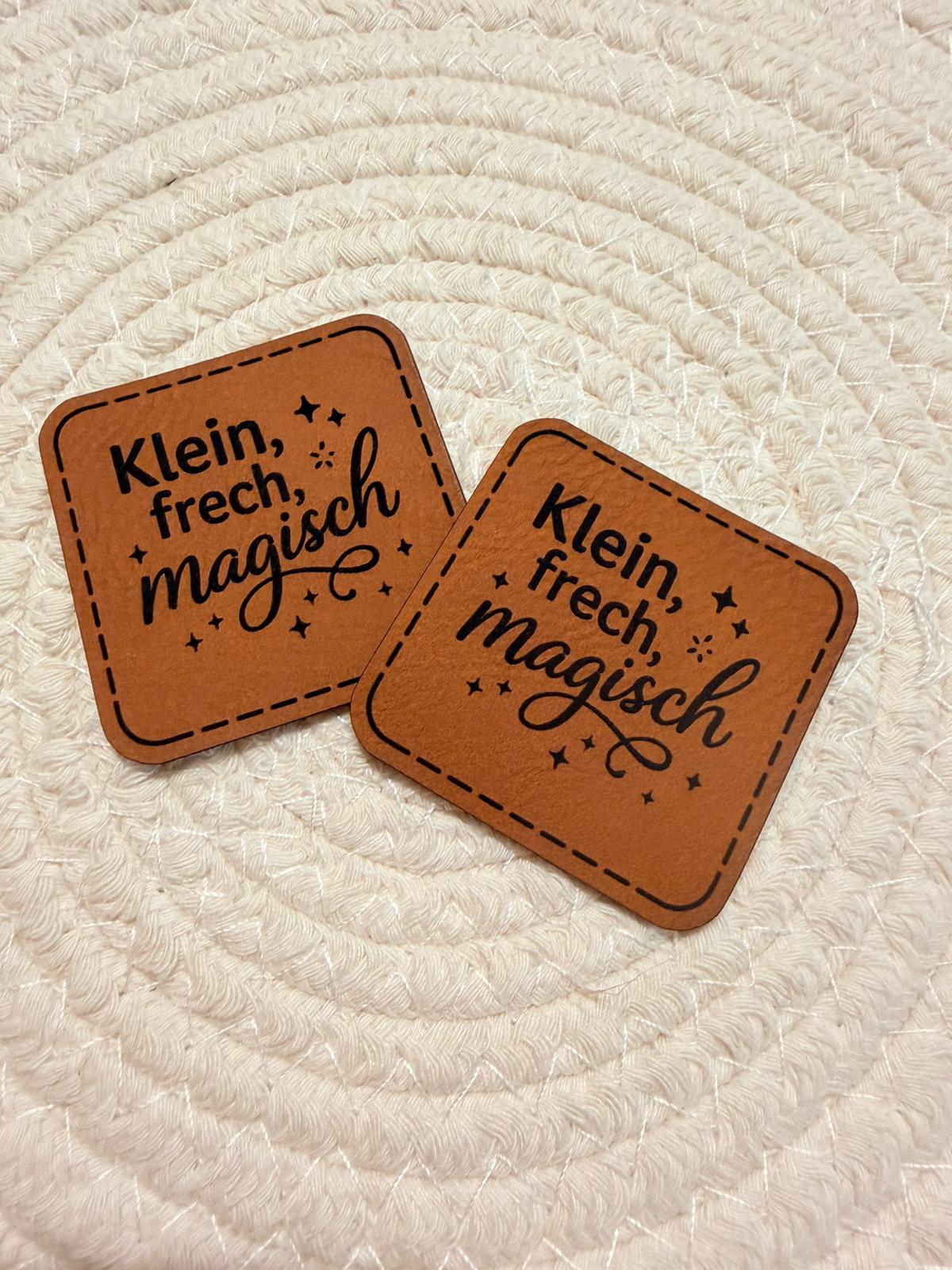 superweiches braunes Kunstlederlabel mit dem Spruch Klein, frech, magisch