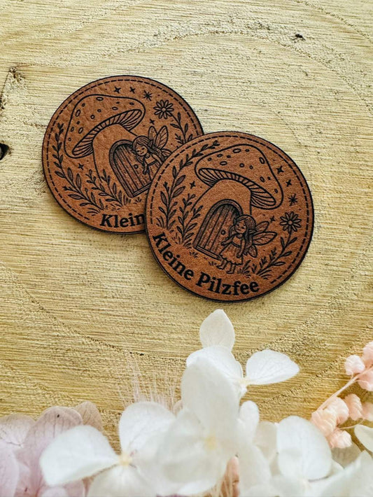 superweiches rundes braunes kunstlederlabel mit dem Spruch Kleine Pilzfee und einer kleinen Fee im Pilzhäuschen abgebildet