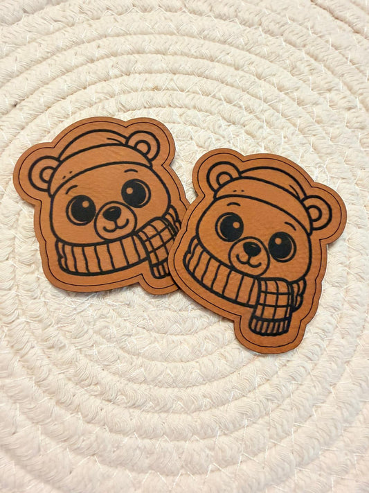 superweiches braunes Kontur Kunstlederlabel mit einem kleinen Bären in einen weichen Schal gemummelt