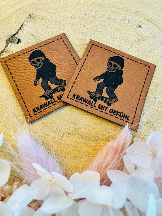 superweiches braunes Kunstlederlabel mit dem Spruch Krawall mit Gefühl und einem skatenden Skelett abgebildet