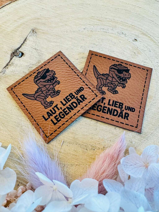 superweiches braunes Kunstleder Label mit einem Robot Dino und dem Spruch Laut Lieb und Legendär abgebildet