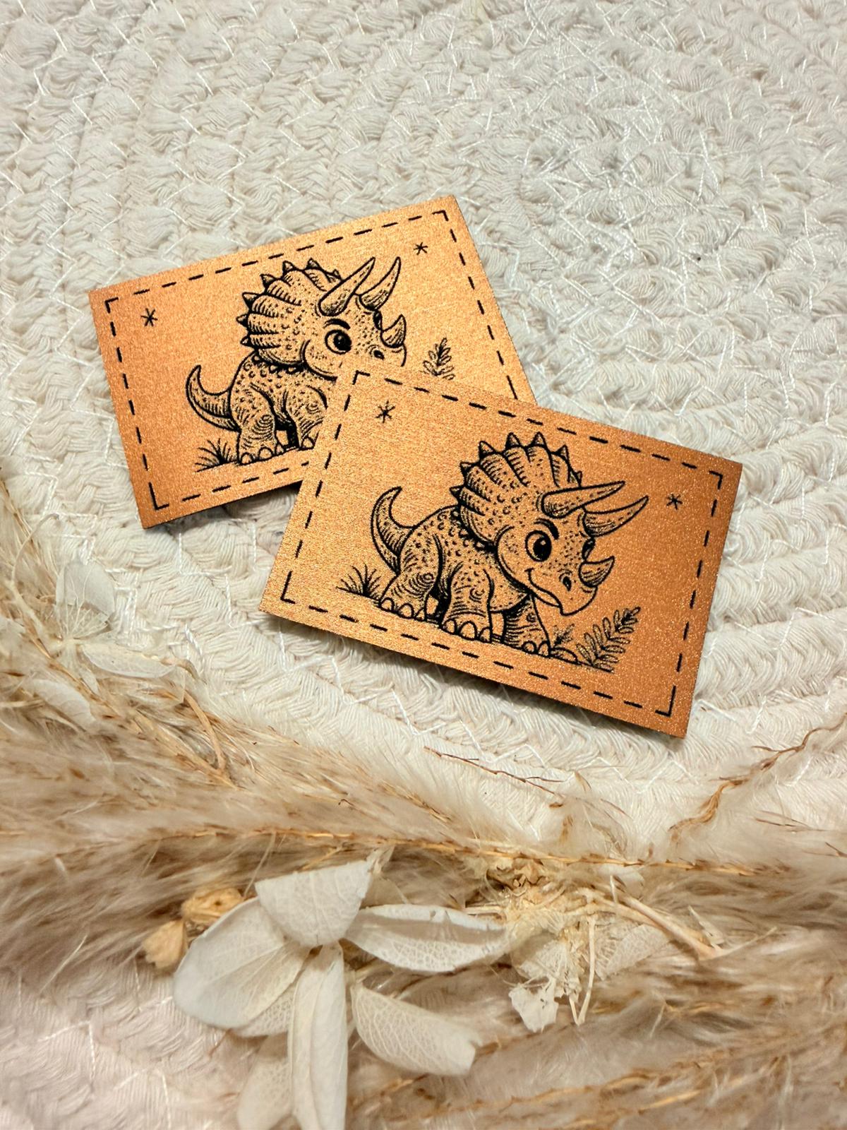 superweiches bronzenfarbenes  gebürstetes Kunstlederlabel mit einem kleinen Triceratops abgebildet