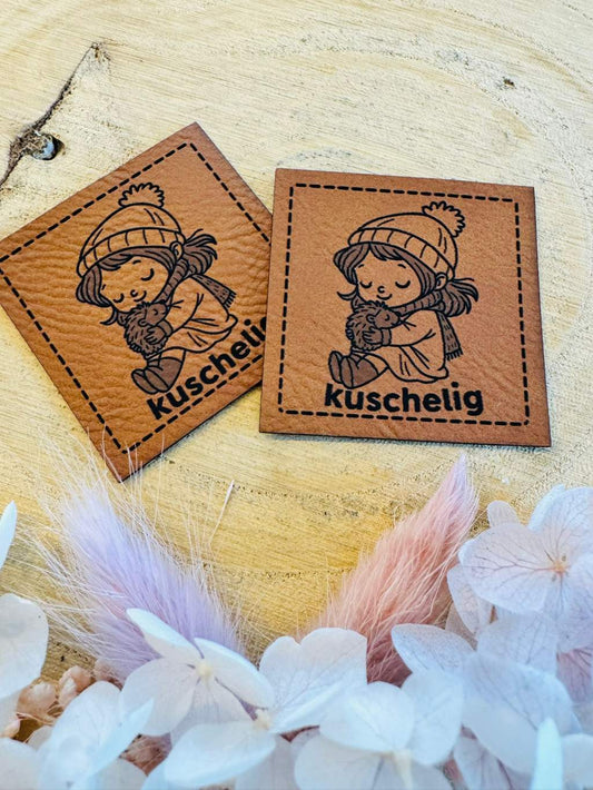 superweiches braunes Kunstleder Label mit einem kleinen Mädchen welches einen kleinen Igel beschützend wärmt