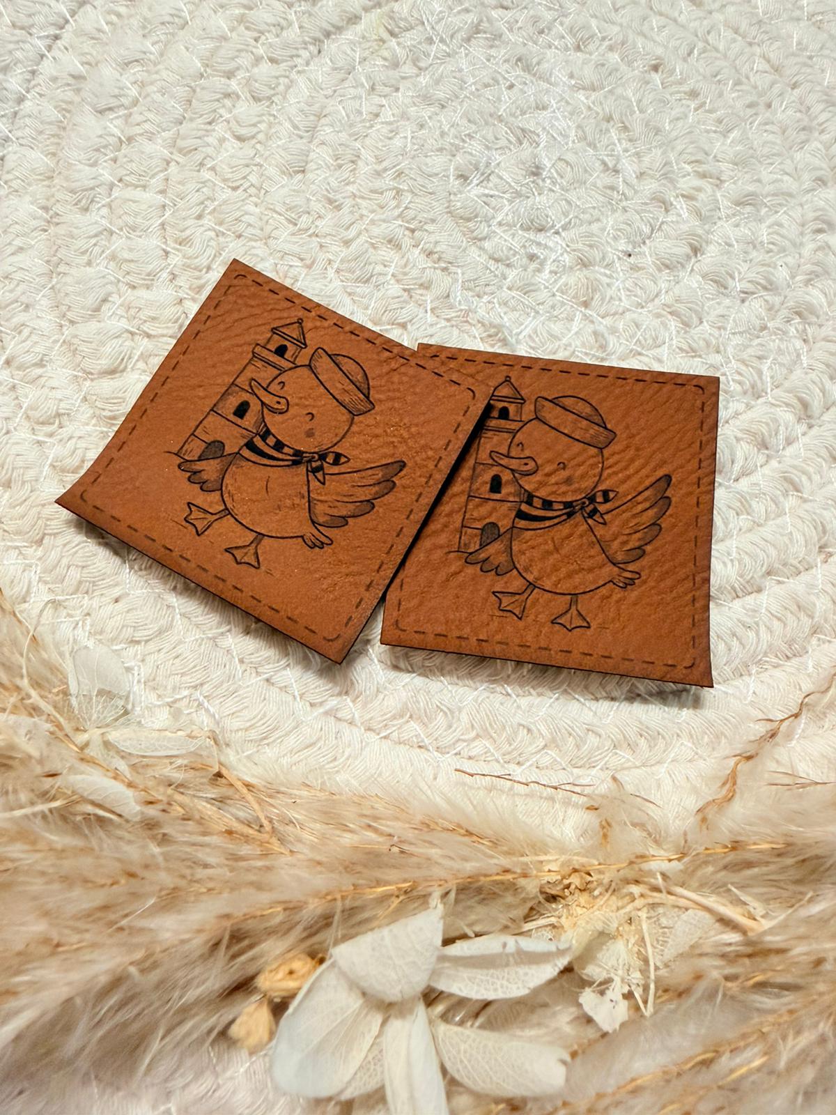 superweiches braunes Kunstlederlabel mit einem kleinen lustigen Entchen im Maritim Look abgebildet