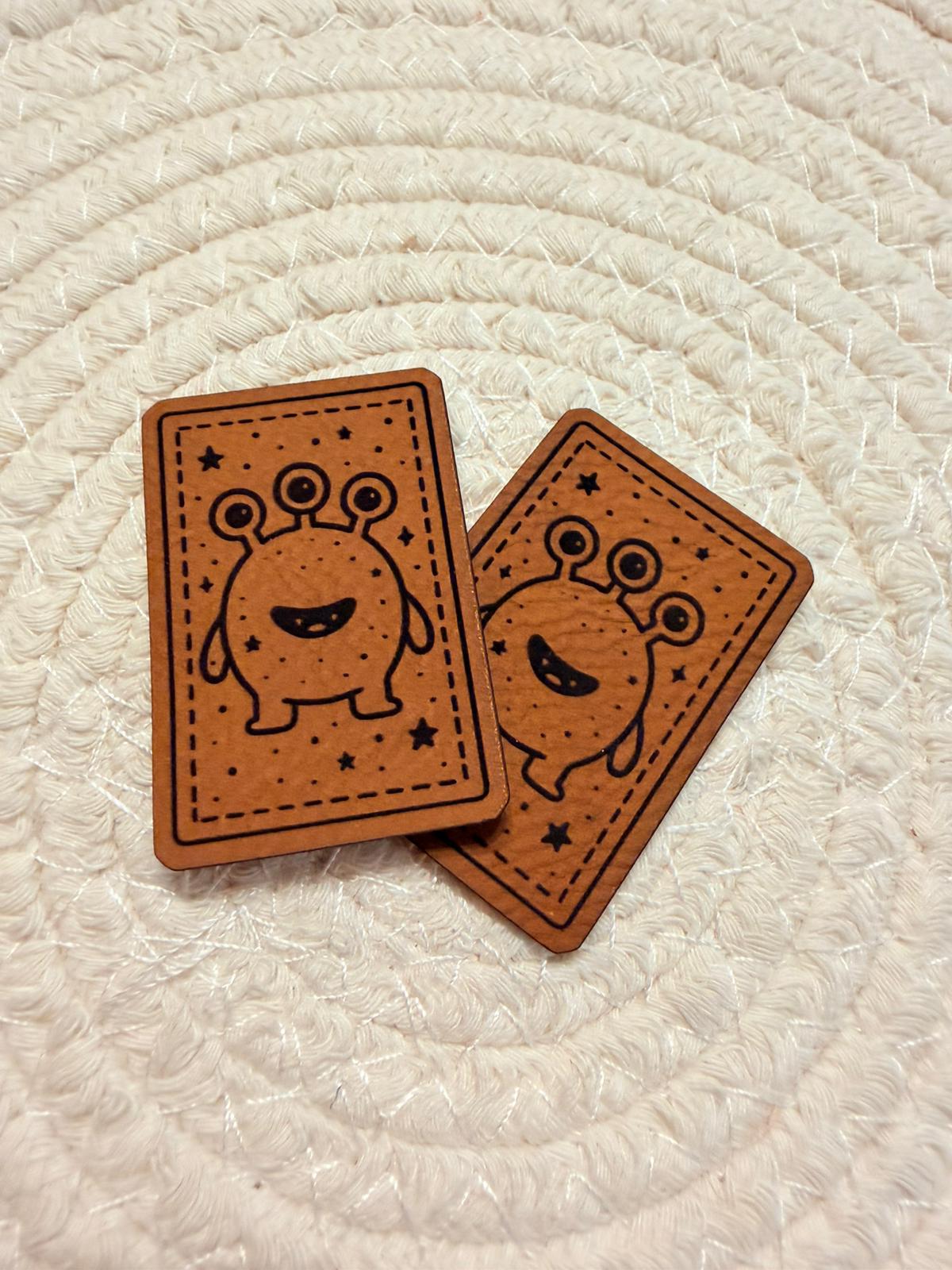 superweiches braunes Kunstlederlabel mit einem dreiäugigen Monsterchen