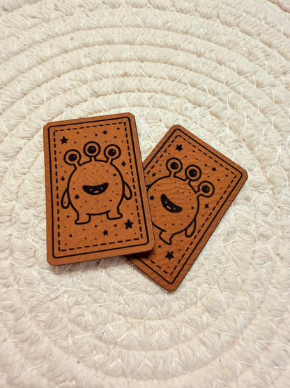 superweiches braunes Kunstlederlabel mit einem dreiäugigen Monsterchen
