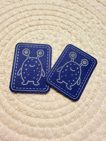 superweiches blaues Kunstlederlabel mit einem kleinen zweiäugigen Monsterchen