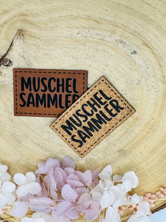 superweiches Kunstlederlabel mit dem Spruch MuschelSammler in zwei Farben abgebildet