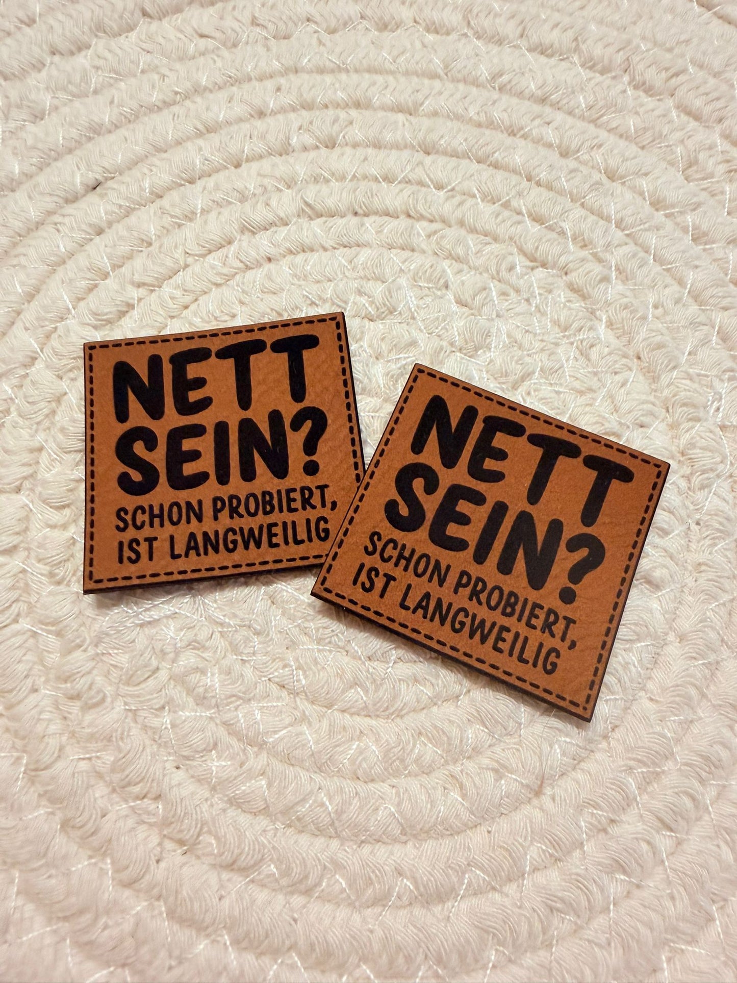 superweiches braunes Kunstlederlabel mit dem Spruch Nett Sein? Schon probiert, ist Langweilig