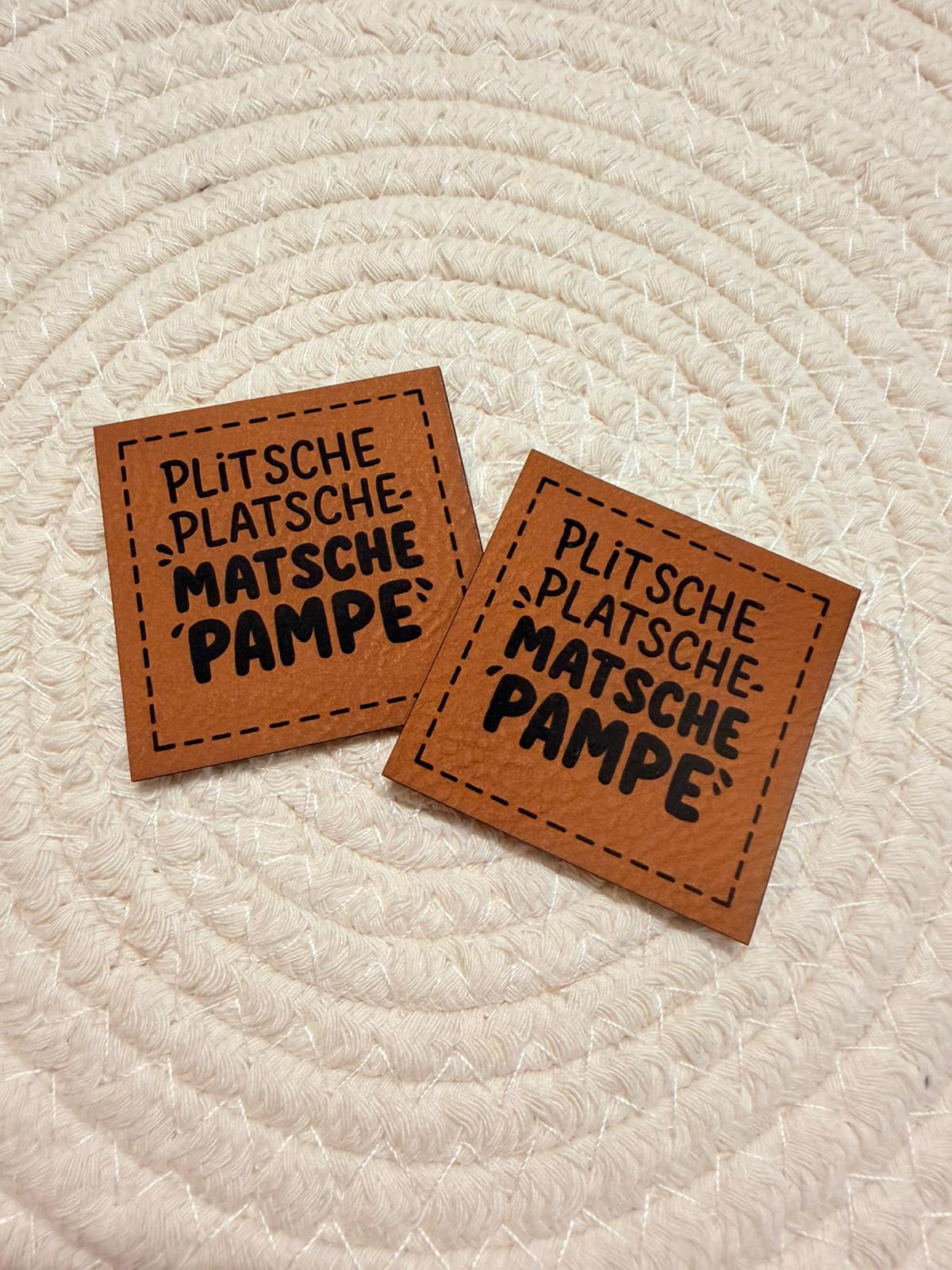 superweiches braunes Kunstlederlabel mit dem Spruch Plitsche-Platsche-Matsche-Pampe