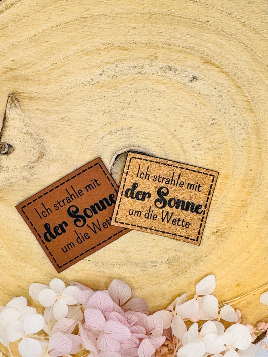 superweiches Kunstlederlabel mit dem Spruch Ich strahle mit der Sonne um die Wette in braun und Korkoptik