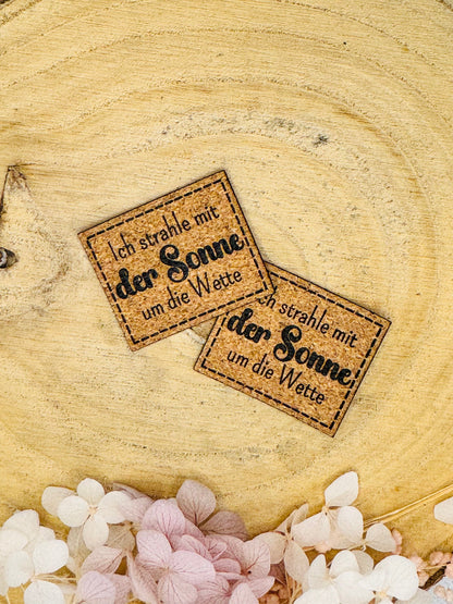 superweiches Kunstlederlabel mit dem Spruch ich strahle mit der Sonne um die Wette in korkoptik