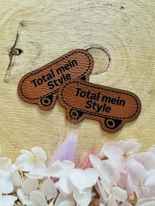 superweiches braunes Kontur Kunstleder Label mit einem Scatbord und dem Spruch Total mein Style abgebildet
