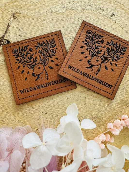 superweiches raunes Kunstlederlabel mit dem Spruch Wild & Waldverliebt mit einem Hirschkopf abgebildet