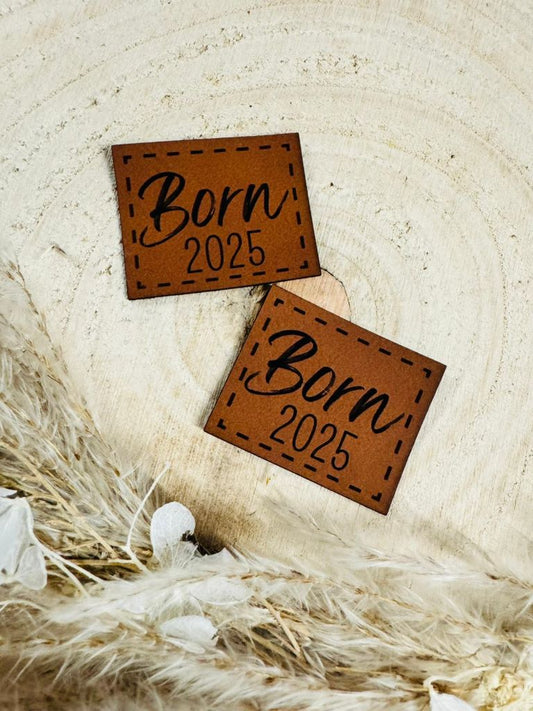 superweiches braunes Kunstlederlabel mit dem Spruch Born2025 in schwarzer Schrift
