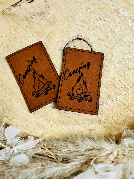 superweiches braunes Kunstlederlabel mit dem Wort Camping und einem Lagerfeuer abgebildet