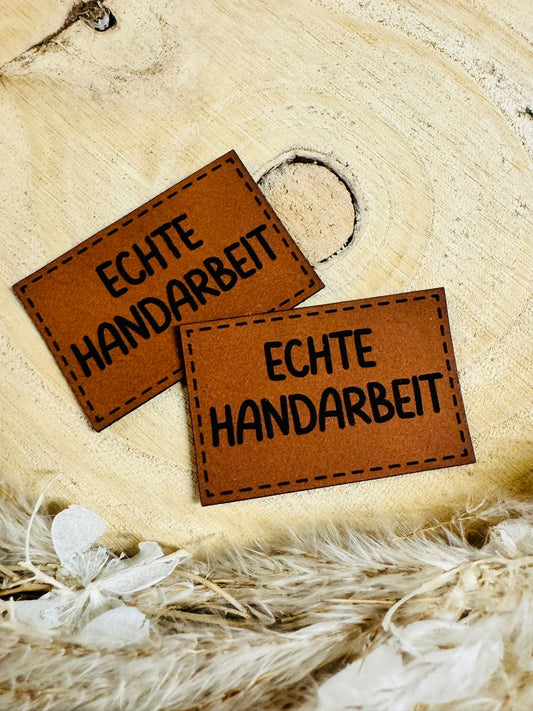 superweiches braunes Kunstlederlabel mit dem Spruch Echte Handarbeit