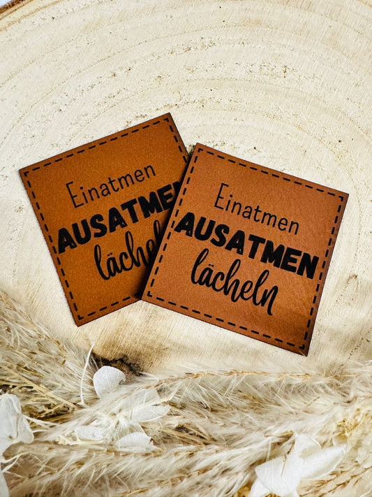 superweiches braunes Kunstlederlabel mit dem Spruch Einatmen Ausatmen lächeln