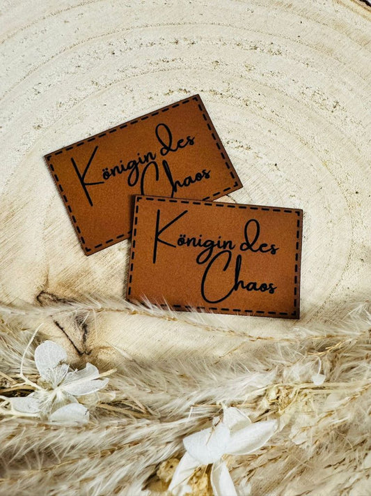 superweiches braunes Kunstlederlabel mit dem Spruch Königin des Chaos in schwarzer Schrift