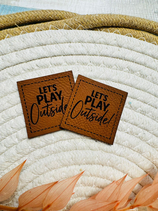 superweiches braunes Kunstlederlabel mit dem Spruch Let`s PLAY Outside!