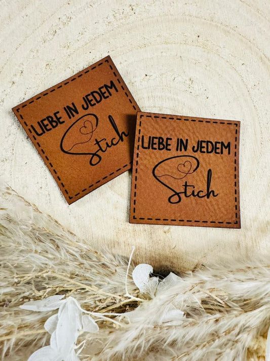superweiches braunes Kunstlederlabel mit dem Spruch Liebe in jedem Stich in schwarzer Schrift
