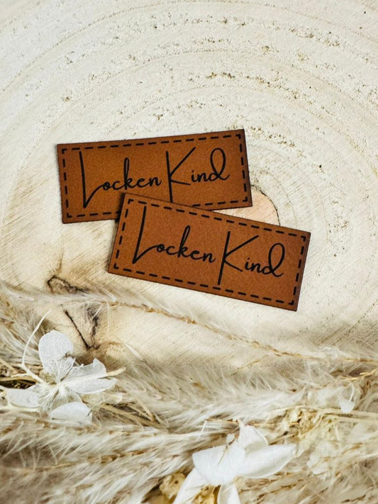 superweiches braunes Kunstlederlabel mit dem Sruch Locken Kind in schwarzer Schrift