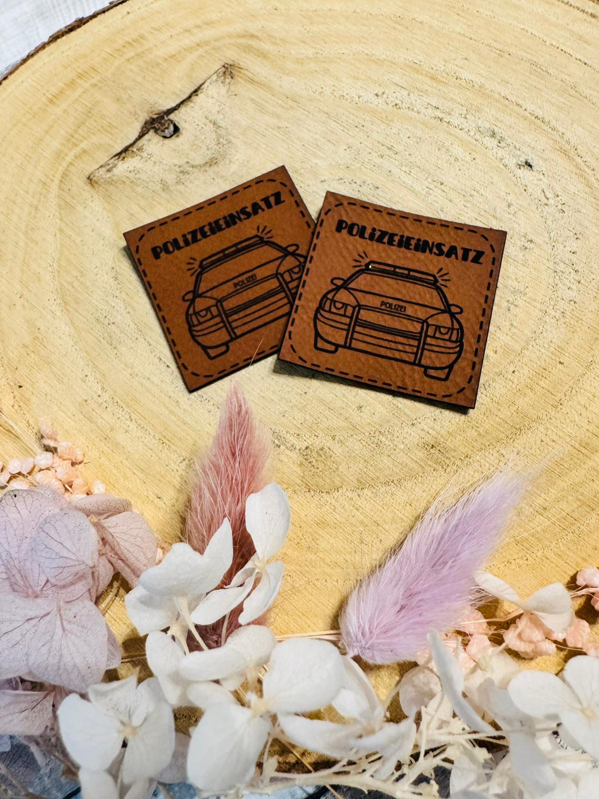 superweiches braunes Kunstlederlabel mit dem Spruch Polizeieinsatz und einem abgebildeten Polizeiauto