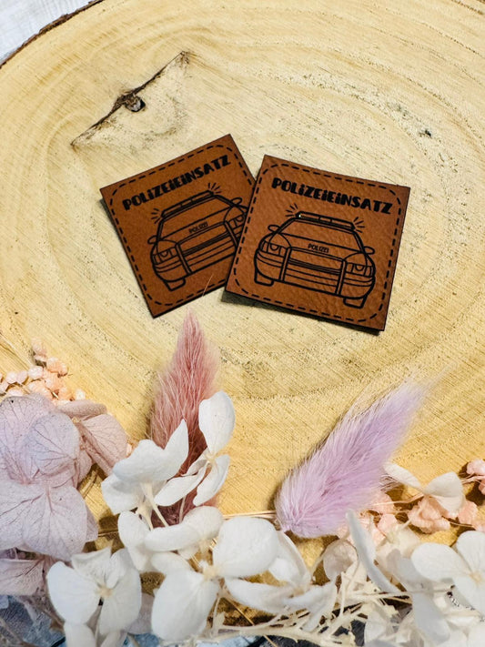 superweiches braunes Kunstlederlabel mit dem Spruch Polizeieinsatz und einem abgebildeten Polizeiauto