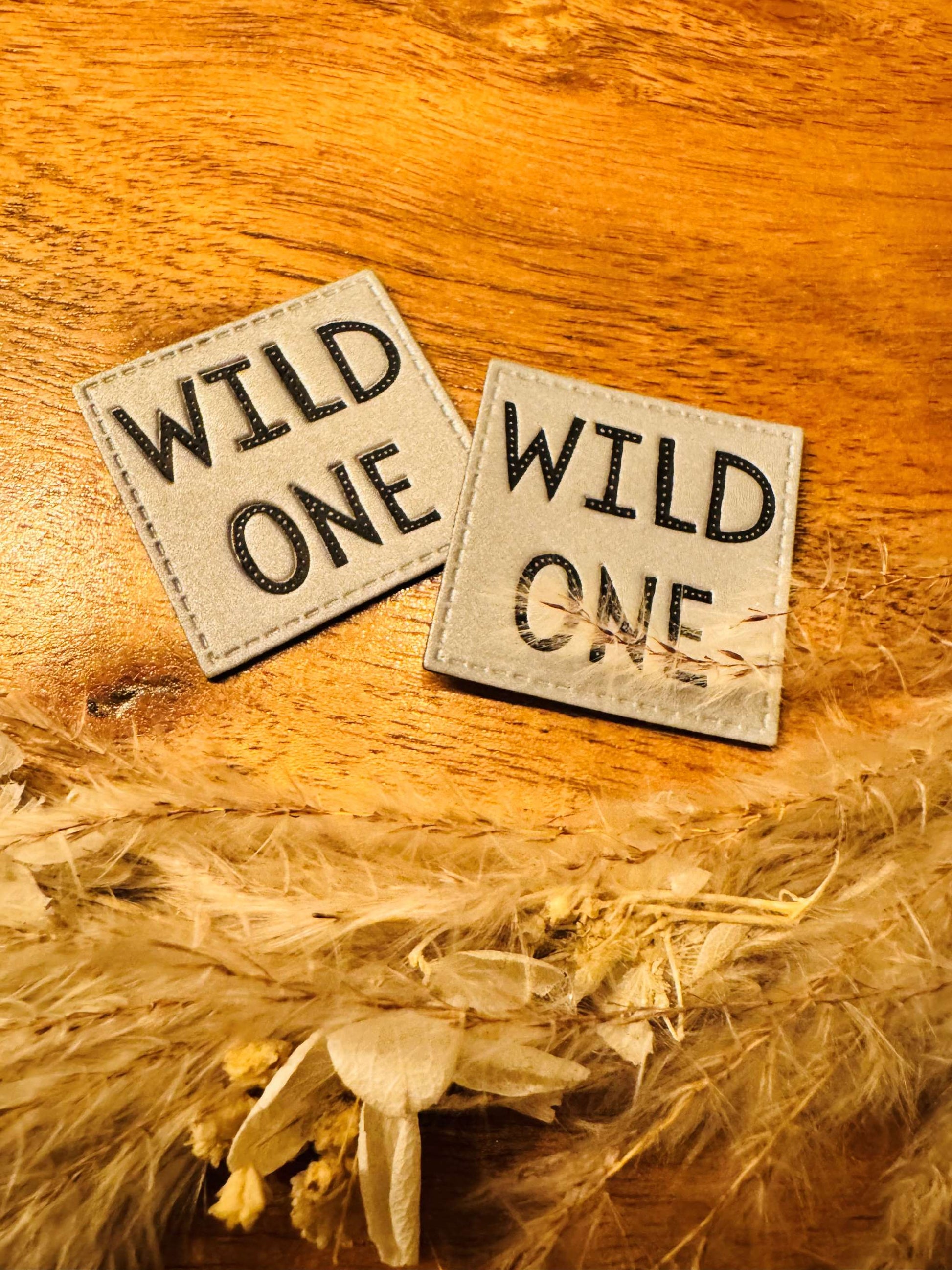silber graues reflektierendes Kunstlederlabel mit dem Spruch Wild One