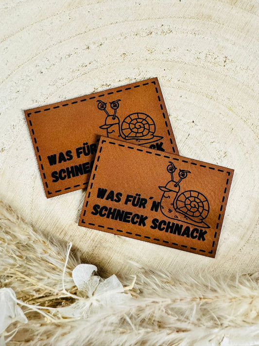 superweiches braunes Kunstlederlabel mit dem Spruch Was für`n Schneck Schnack und einer kleinen Schnecke abgebildet