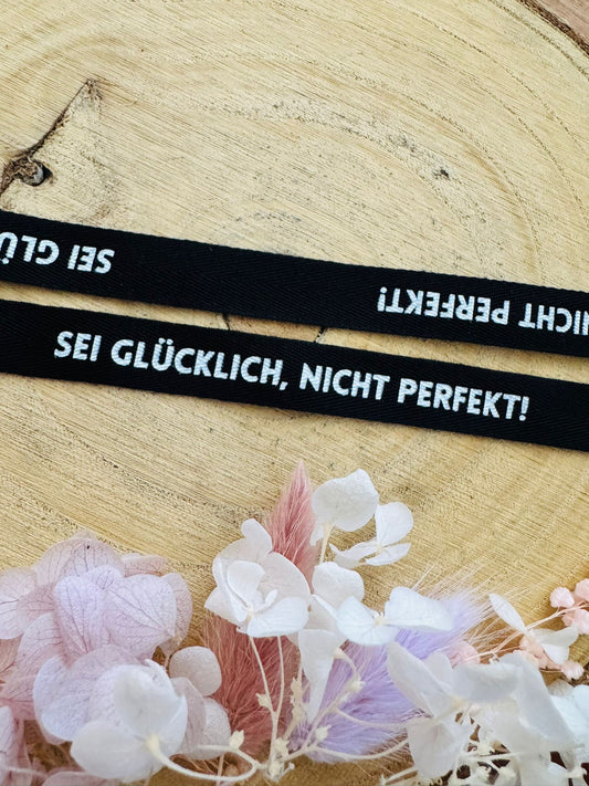 schönes schwarzes Baumwoll Webband mit dem durchgehenden Spruch Sei Glücklich, Nicht Perfekt! in weisser Schrift