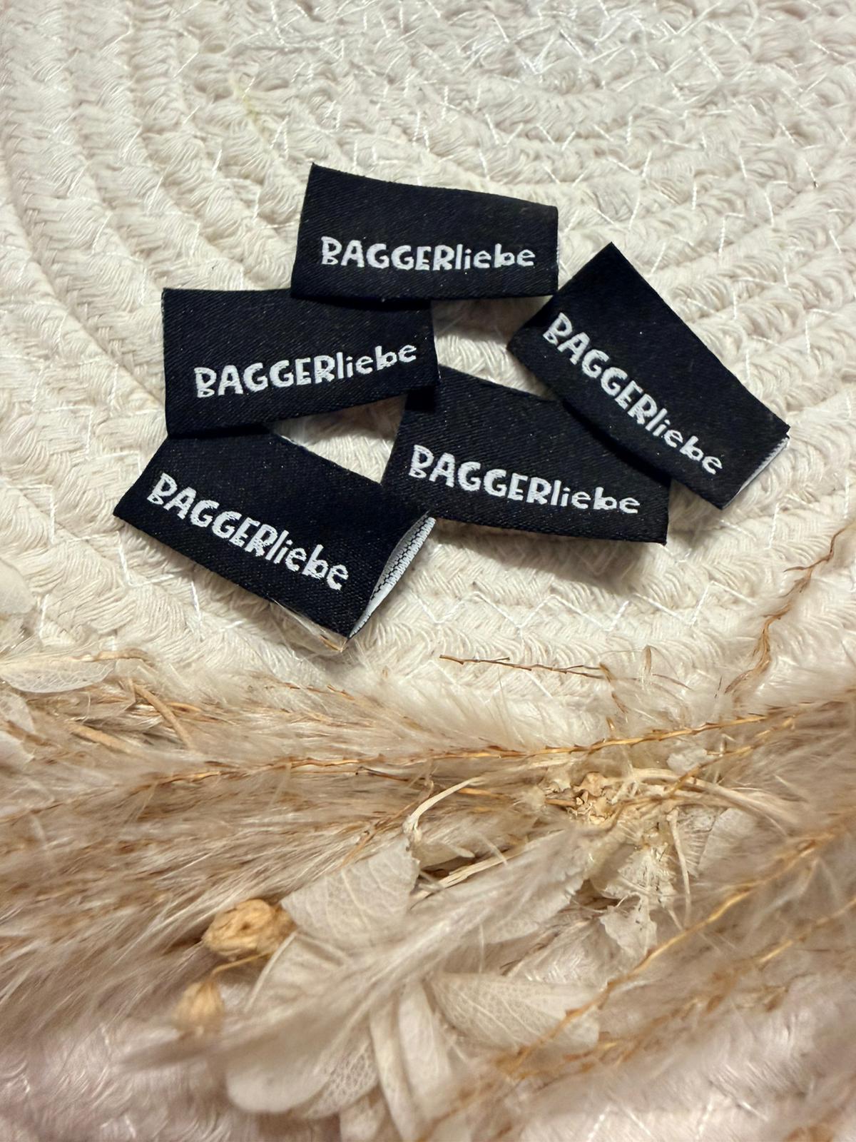 tolles neues Klapp Weblabel von Bienenkinder mit dem Spruch Baggerliebe in schwarzer Ausführung