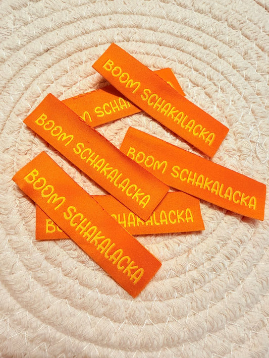 tolles neues Klapp Weblabel der Bienenkinder zum Einnähen mit dem Spruch " Boom Schakalacka" in orangener Ausführung