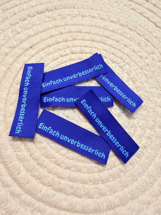 tolles neues Klapp Weblabel der Bienenkinder zum Einnähen mit dem Spruch Einfach unverbesserlich in blauer Ausführung
